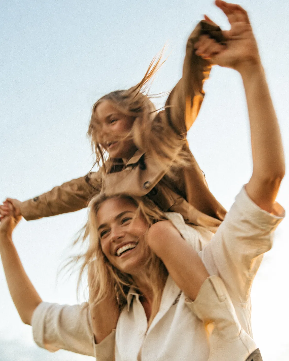 Madre e hija sonriendo al aire libre en un entorno privado